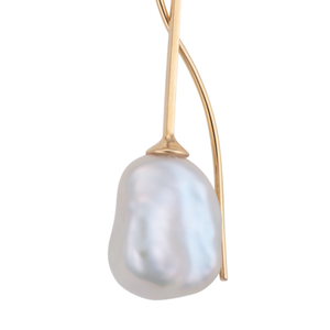 A close- up image of a white keshi pearl earring on a 9ct gold setting.