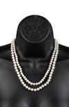 An image of a graduated double-strand white freshwater cultured pearl necklace on a black mannequin