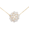 A close-up image of a white snowball pearl cluster necklace on a gold chain