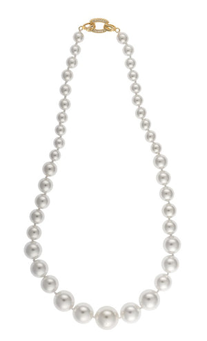 An image of a white pearl necklace with a decorative gold and crystal clasp
